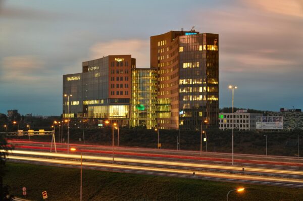 Kantoorgebouwen aan de Fascinatio Boulevard in Capelle aan den IJssel, met lichtsporen van verkeer op de snelweg in de voorgrond tijdens schemering.